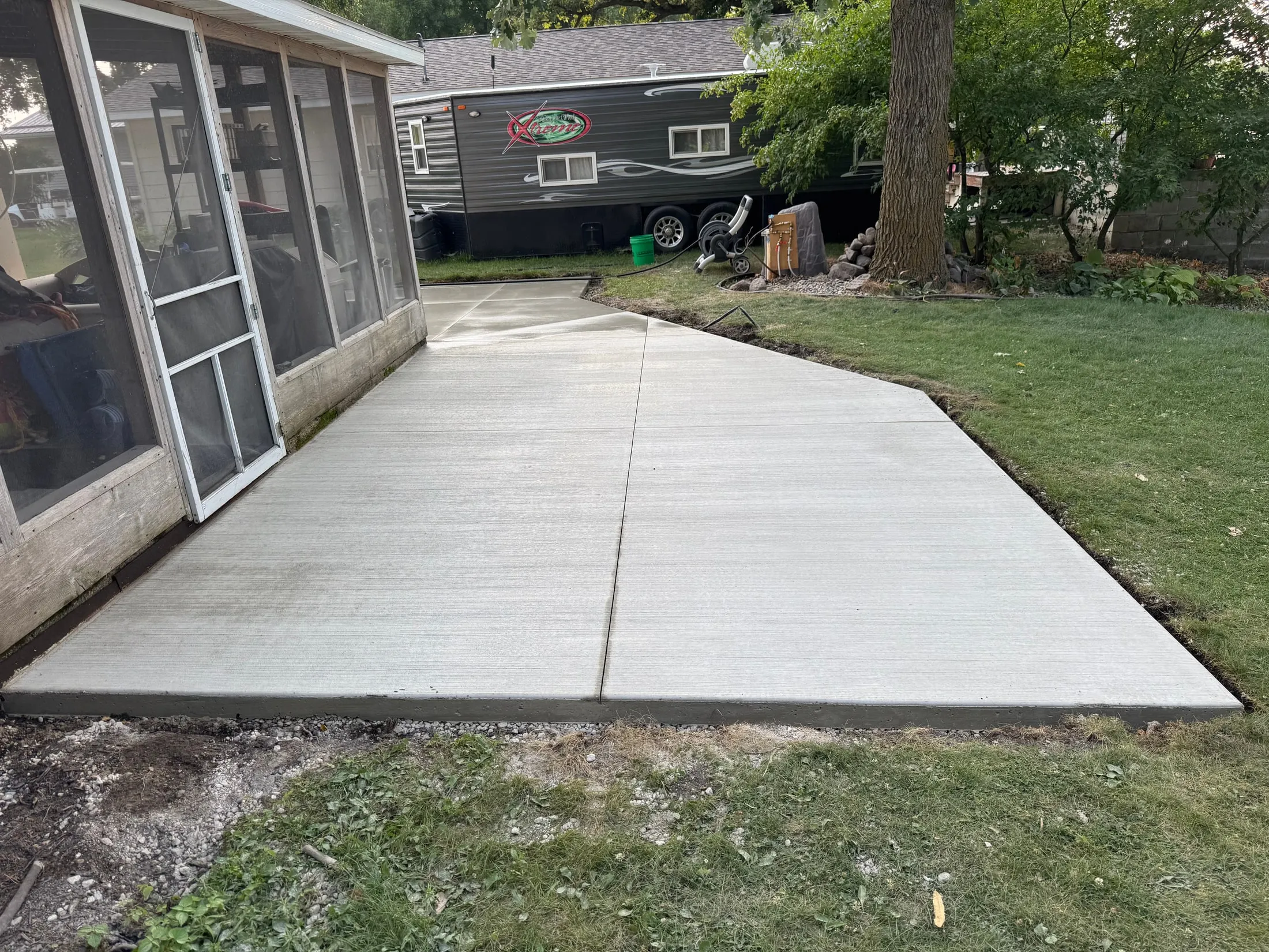 Concrete approach with a rounded edge around a screened porch.