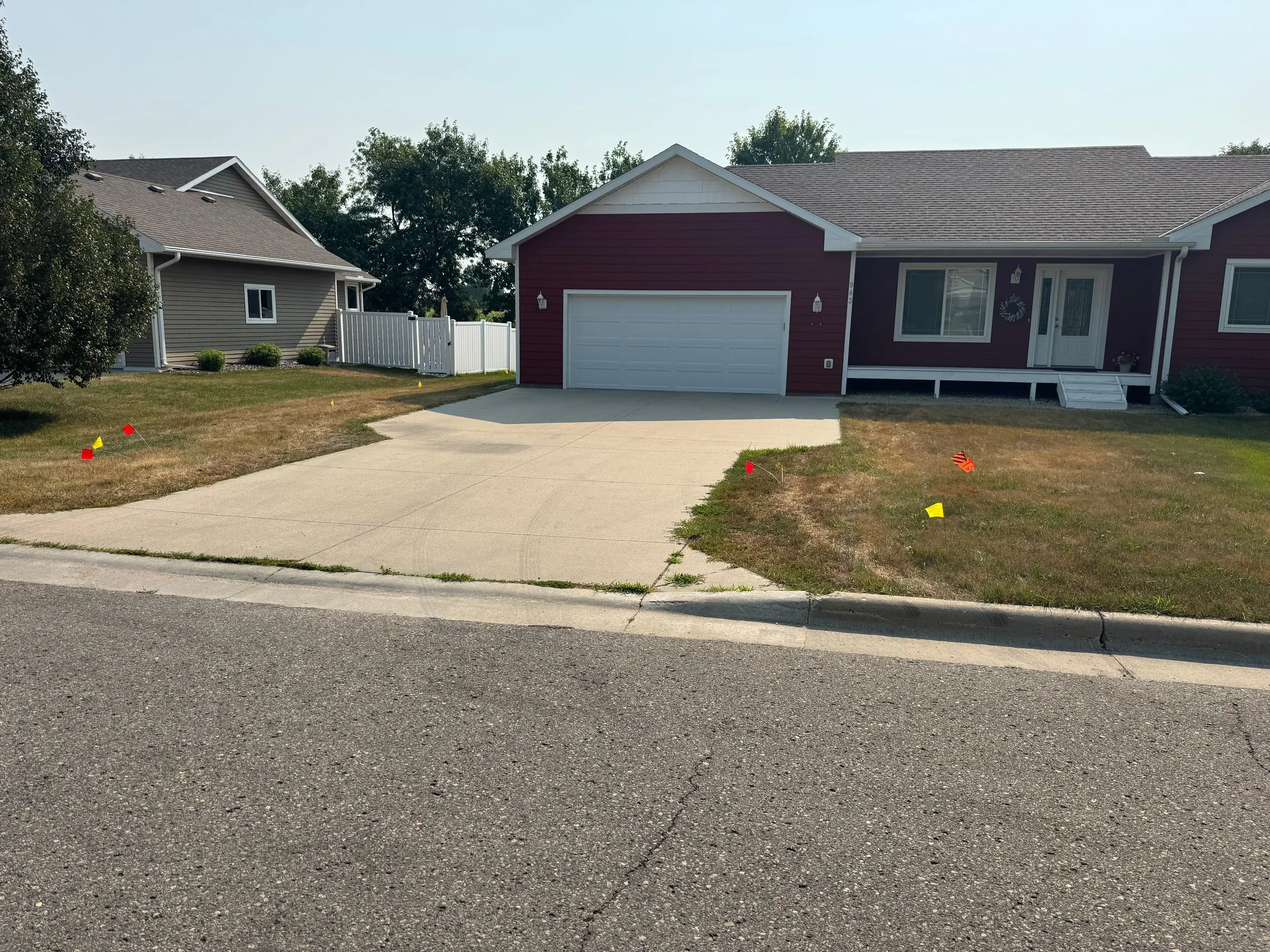 After: concrete driveway at the same red home.