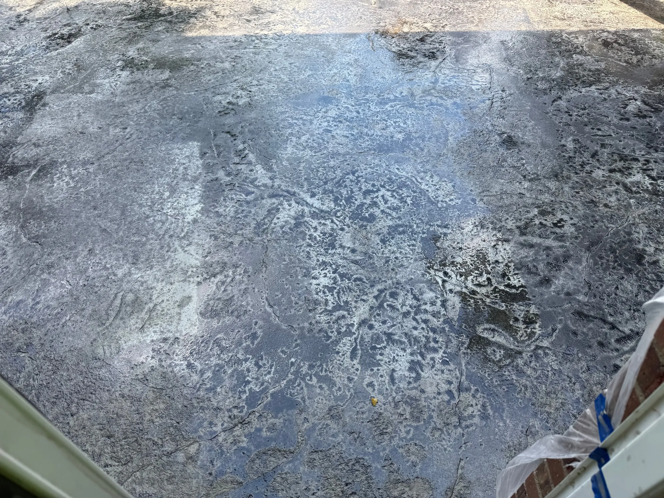 Patterned concrete patio beside a home.