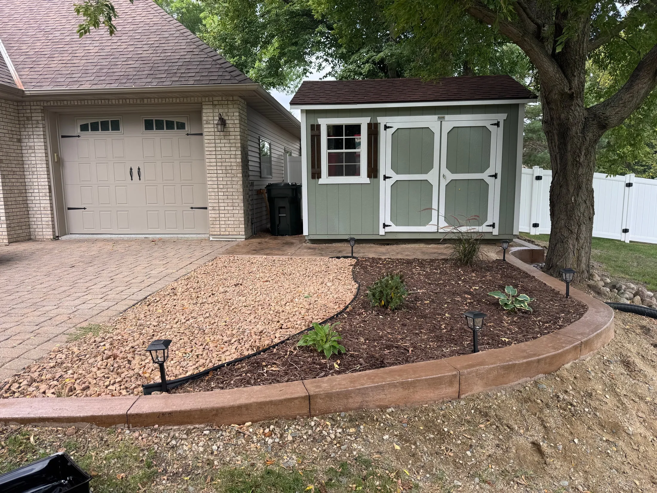 Curved landscape edging around stone and planted beds.