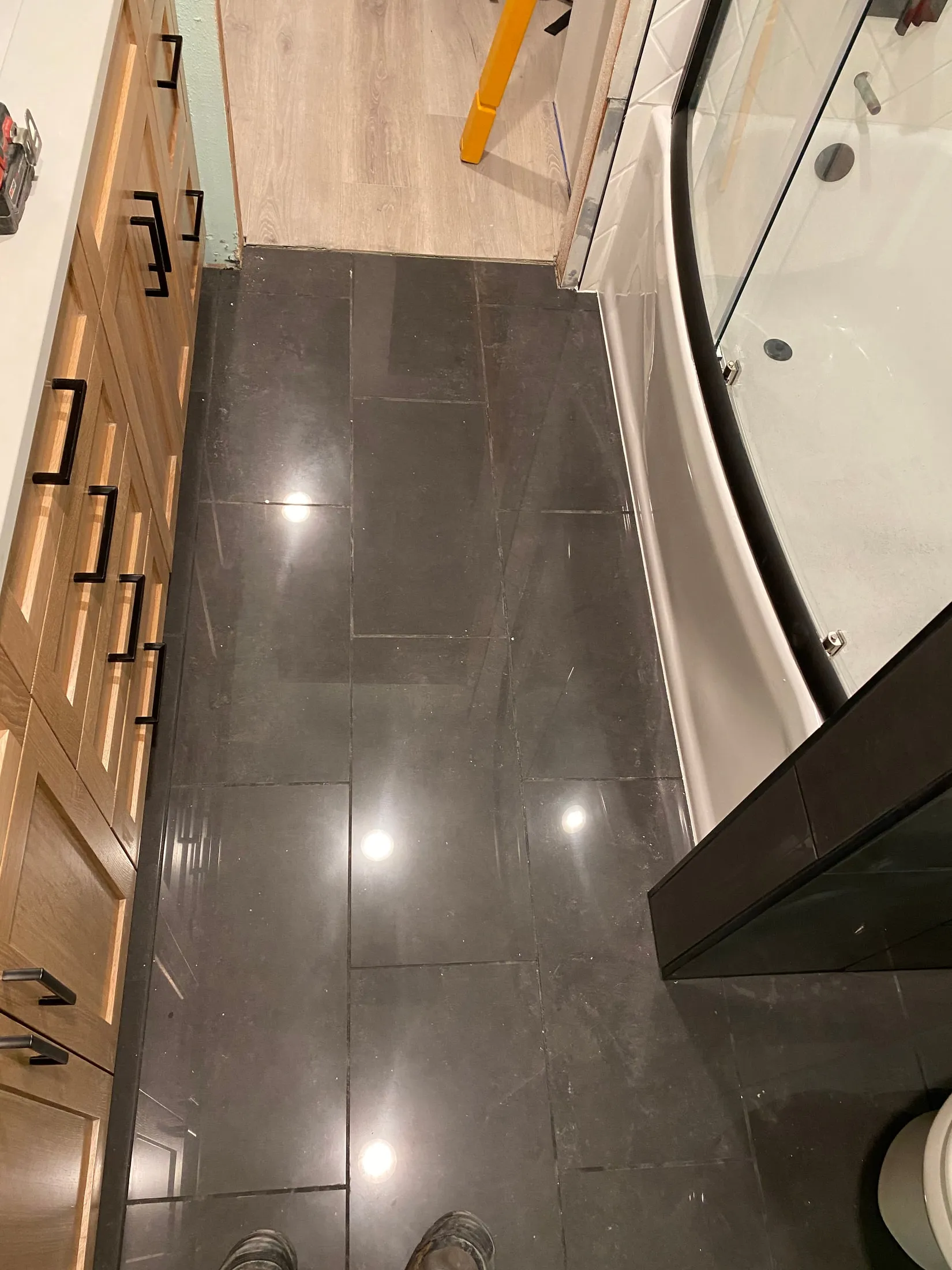 Dark tiled bathroom floor in the herringbone project.
