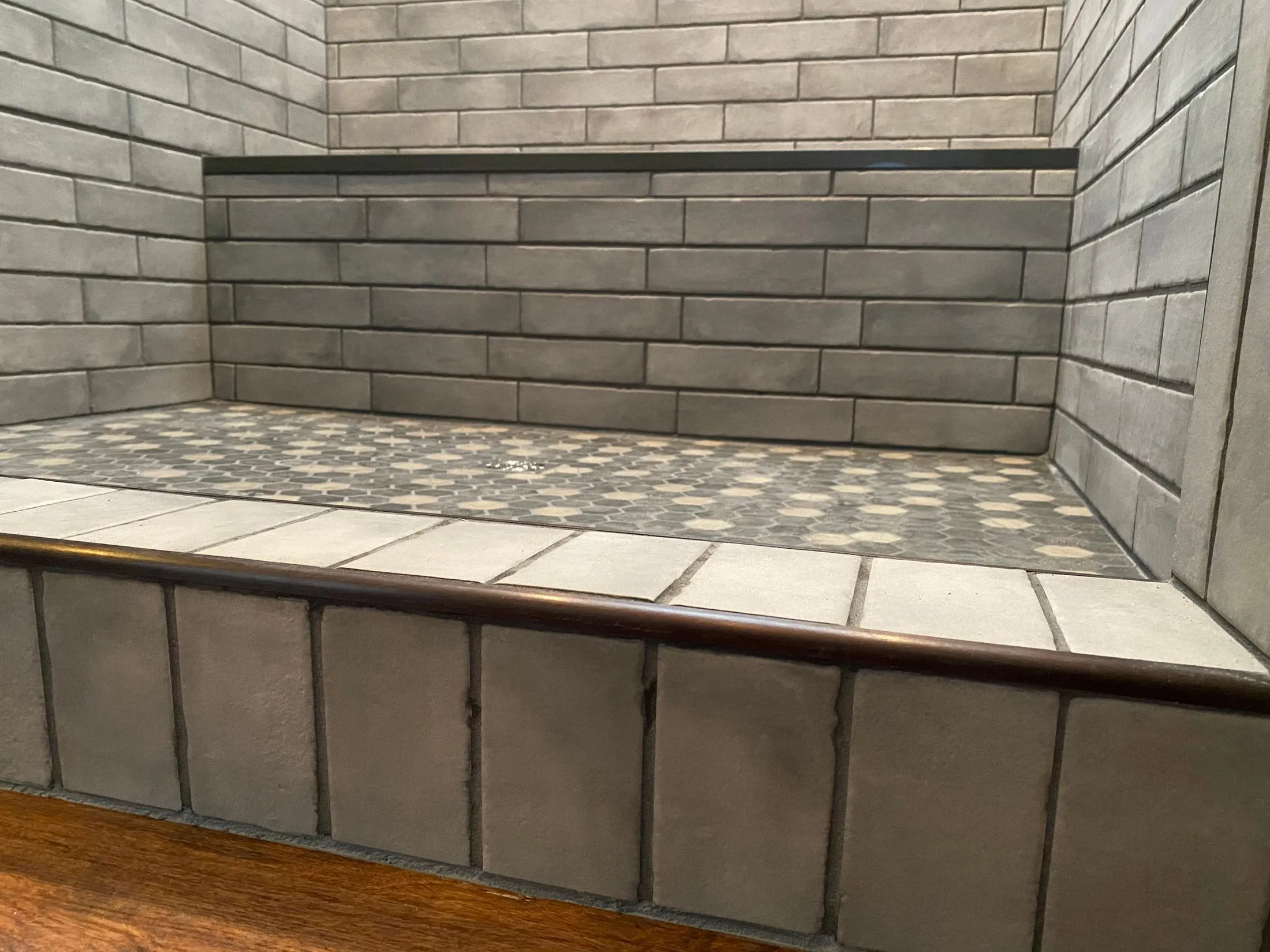Close detail of the gray-tile shower bench.
