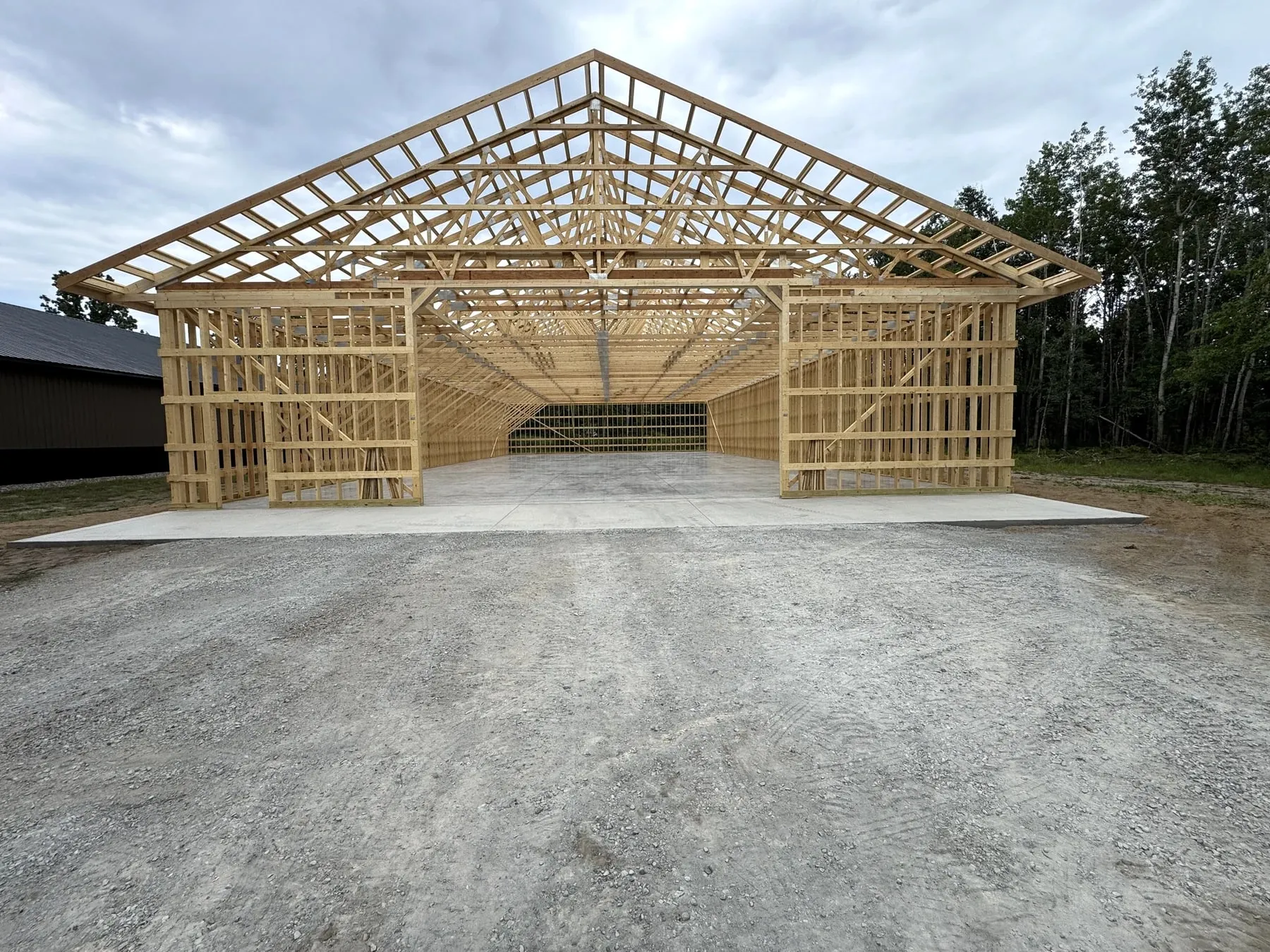 Pole-shed concrete floor beneath a timber building frame, August 2025.