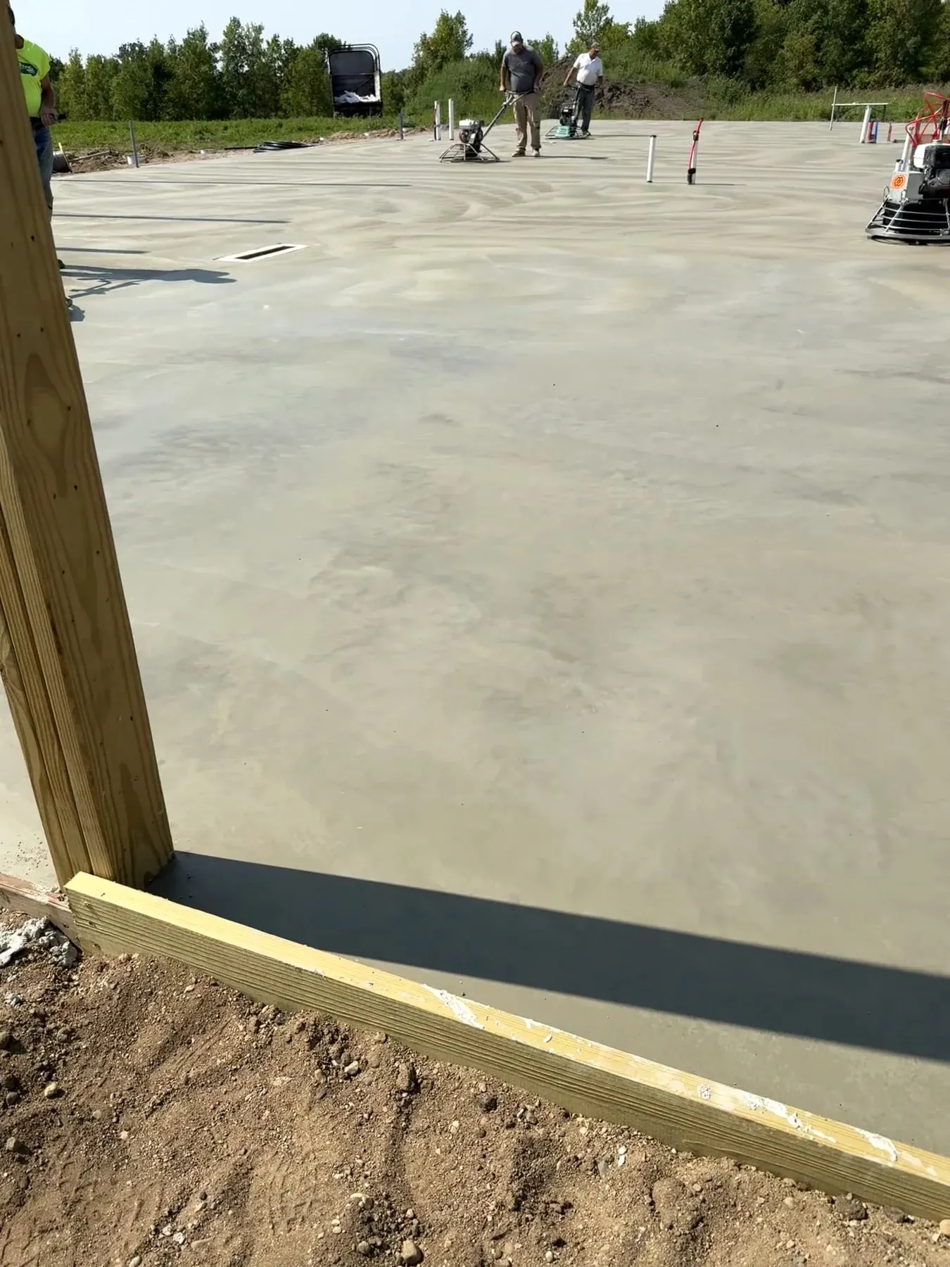 Concrete slab during finishing inside an open pole frame, September 2024.