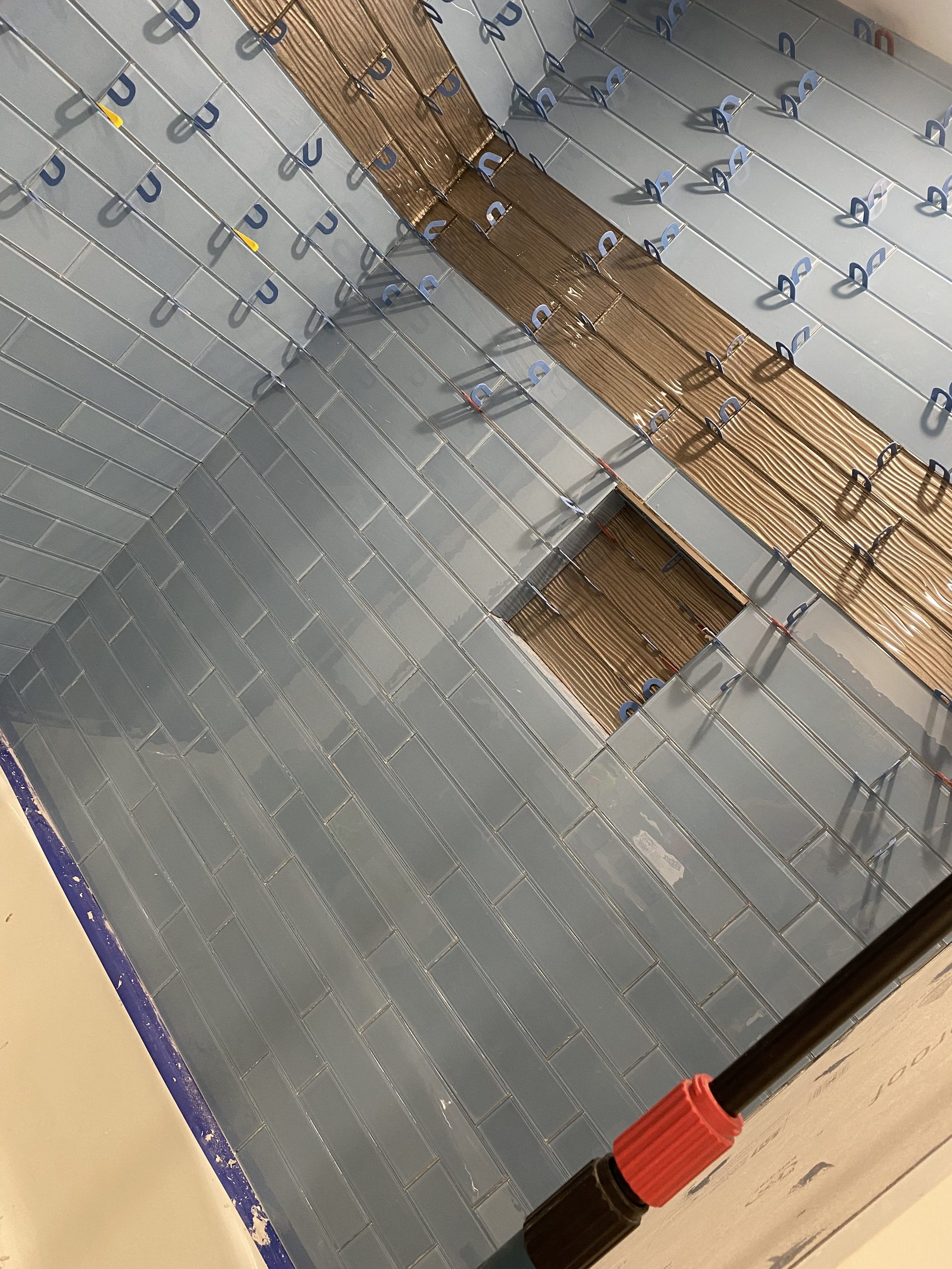 Drywall sheets hung on ceiling joists with visible fasteners and wood framing.